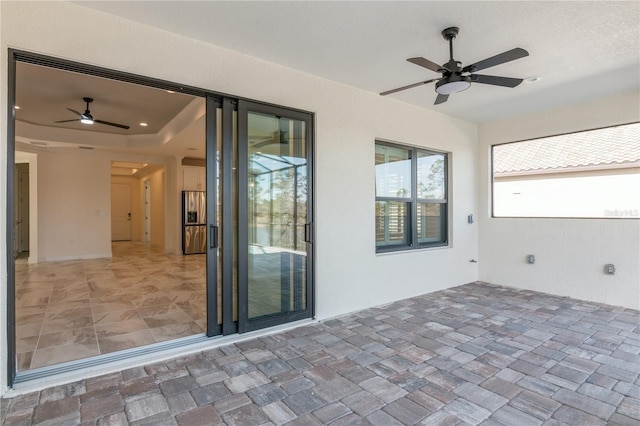 interior space with a tray ceiling and ceiling fan