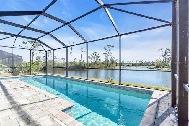 view of swimming pool with glass enclosure, a water view, and a patio