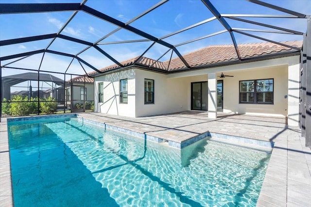 view of swimming pool featuring glass enclosure, ceiling fan, and a patio area