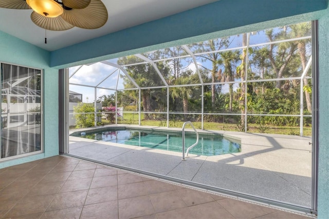 view of swimming pool featuring ceiling fan, glass enclosure, and a patio area