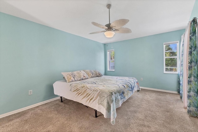 carpeted bedroom featuring ceiling fan and multiple windows