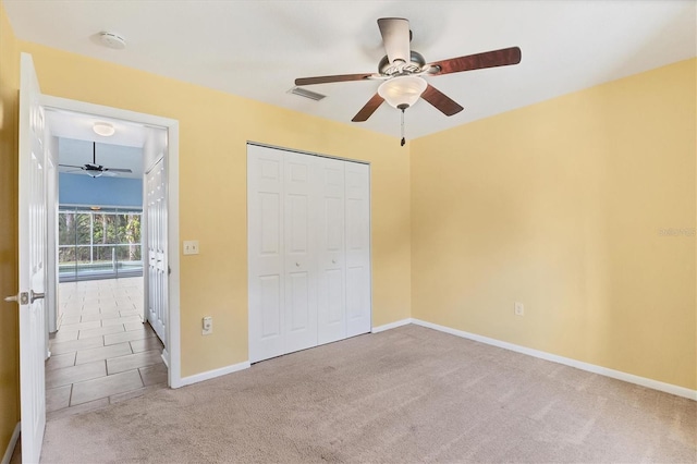 unfurnished bedroom with light carpet, ceiling fan, and a closet