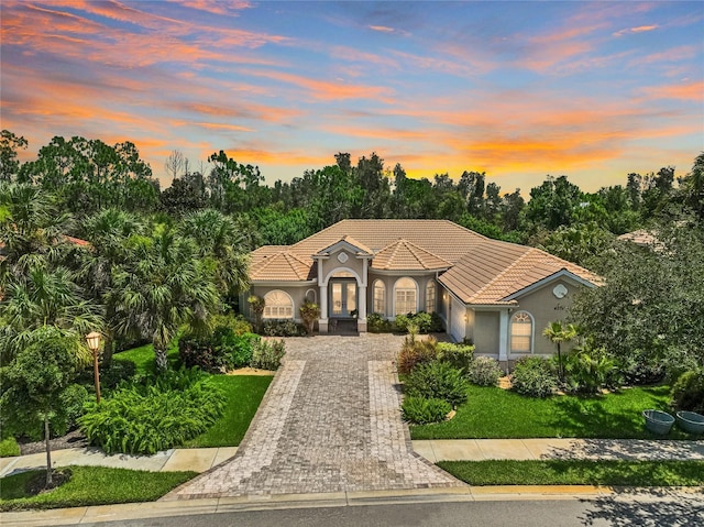 mediterranean / spanish home featuring a yard