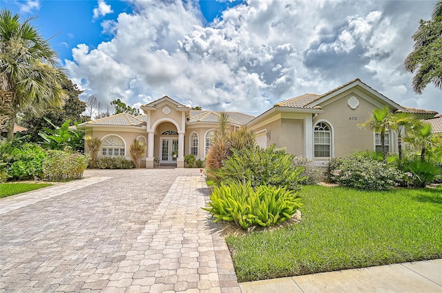 mediterranean / spanish home with french doors and a front yard