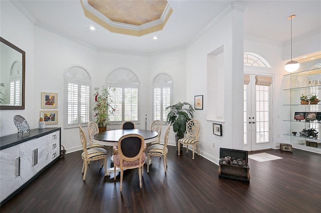 dining area with french doors, dark hardwood / wood-style flooring, a raised ceiling, and crown molding