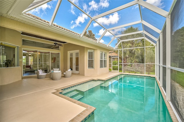 view of pool with ceiling fan, a lanai, and a patio