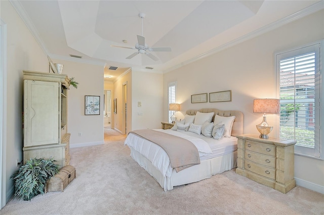 bedroom with multiple windows, light colored carpet, a raised ceiling, and ceiling fan