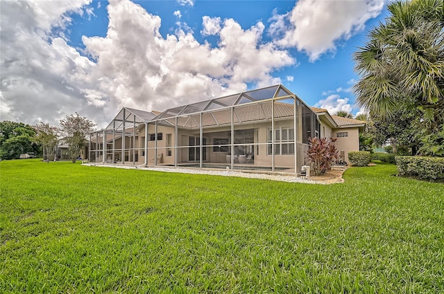 rear view of property featuring a lawn and glass enclosure