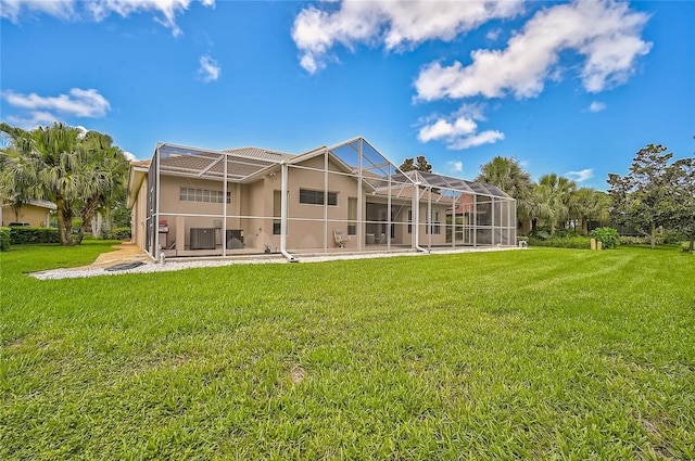 back of property with a lawn and a lanai