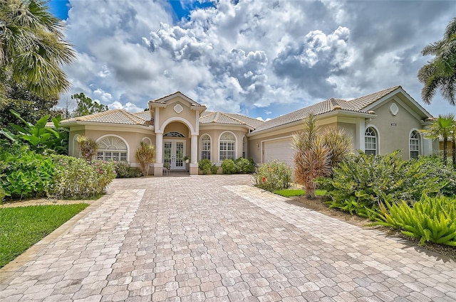 mediterranean / spanish-style home with french doors and a garage