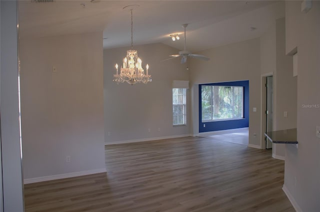 unfurnished room with hardwood / wood-style flooring, lofted ceiling, and ceiling fan with notable chandelier