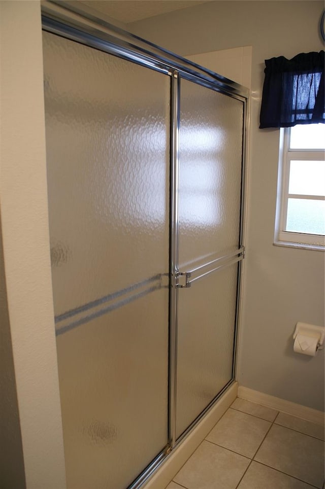 bathroom with walk in shower and tile patterned floors