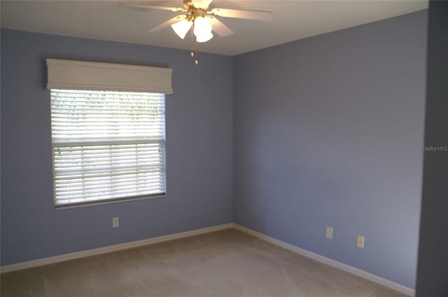 spare room with carpet floors, a healthy amount of sunlight, and ceiling fan