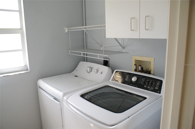 washroom featuring cabinets and washer and clothes dryer