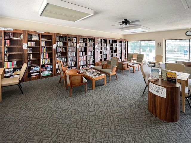 dining area with a textured ceiling, dark carpet, and ceiling fan