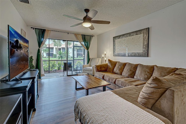 living room with floor to ceiling windows, ceiling fan, hardwood / wood-style floors, and a textured ceiling