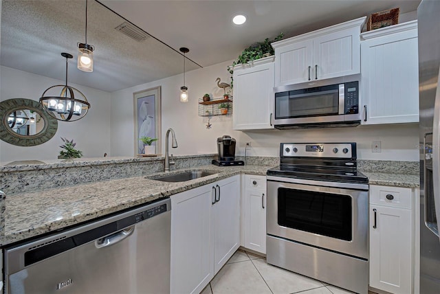 kitchen with white cabinets, pendant lighting, sink, and appliances with stainless steel finishes