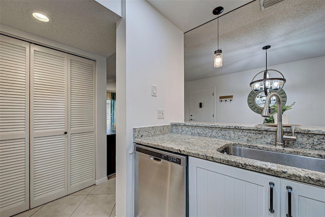 kitchen with light stone countertops, stainless steel dishwasher, sink, decorative light fixtures, and white cabinetry