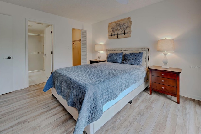 bedroom with light hardwood / wood-style floors, a spacious closet, and a closet