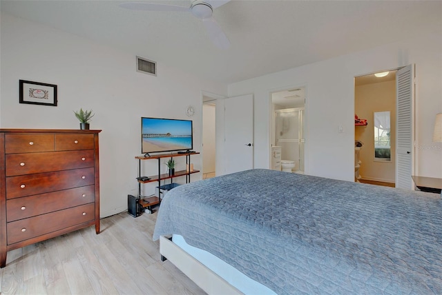 bedroom featuring ensuite bathroom, light hardwood / wood-style flooring, and ceiling fan