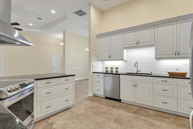 kitchen featuring tasteful backsplash, visible vents, ventilation hood, appliances with stainless steel finishes, and a sink