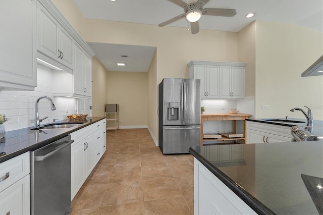 kitchen featuring a sink, stainless steel appliances, dark countertops, and white cabinets