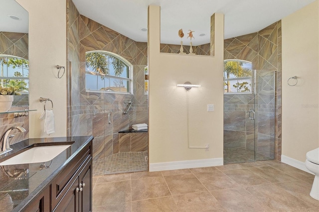 bathroom with tile patterned flooring, a shower stall, baseboards, toilet, and vanity