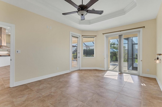 unfurnished room with ceiling fan, baseboards, ornamental molding, light tile patterned floors, and a raised ceiling