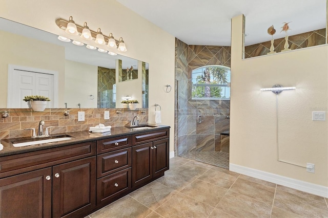 full bathroom featuring a sink, backsplash, double vanity, and a shower stall