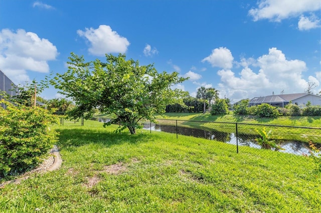 view of yard with a water view and fence