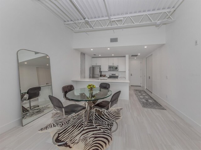 dining space featuring a high ceiling and sink