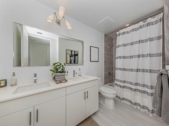 full bathroom featuring vanity, an inviting chandelier, toilet, and shower / bath combo with shower curtain