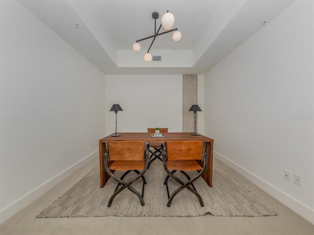 carpeted office space with an inviting chandelier and a raised ceiling