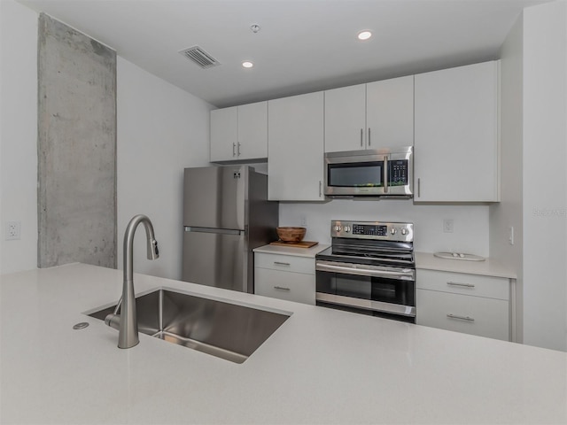 kitchen with white cabinets, sink, and appliances with stainless steel finishes