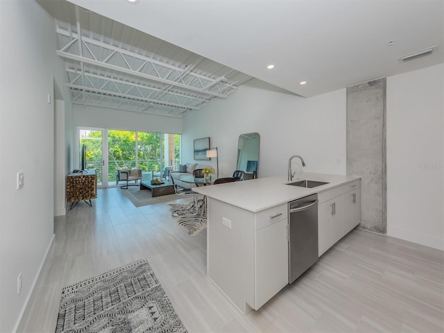 kitchen with kitchen peninsula, white cabinetry, sink, and stainless steel dishwasher