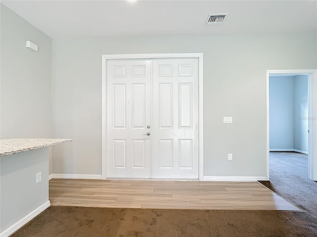 unfurnished bedroom with a closet and light hardwood / wood-style floors