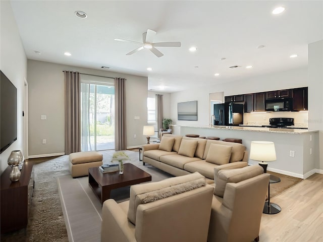 living room featuring ceiling fan and light wood-type flooring