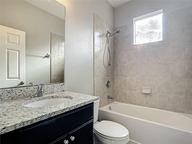 full bathroom with toilet, vanity, and tiled shower / bath