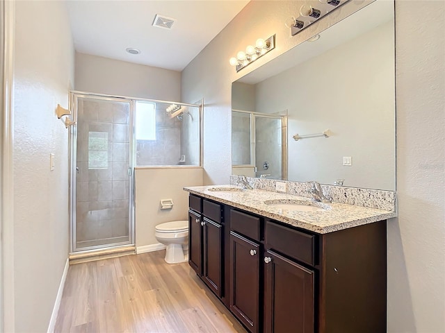 bathroom featuring toilet, a shower with shower door, wood-type flooring, and vanity