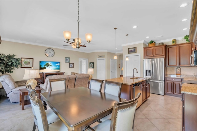 tiled dining area featuring crown molding, sink, and a chandelier