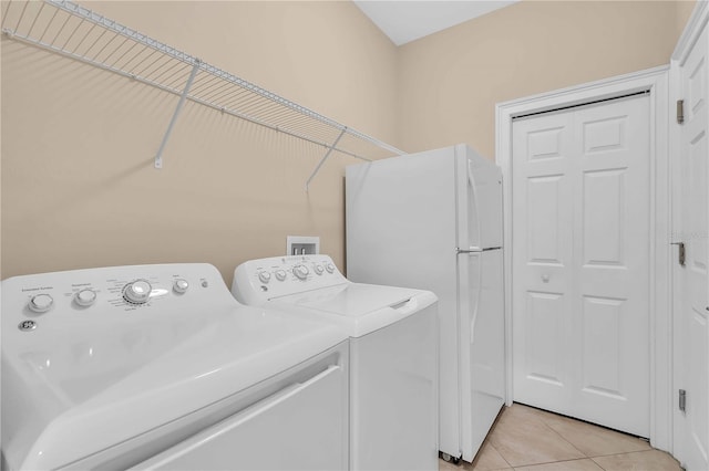 washroom featuring light tile patterned flooring and washing machine and dryer