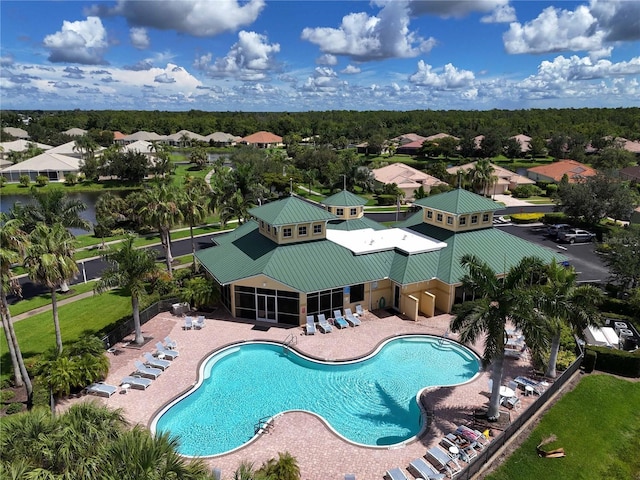 view of swimming pool featuring a patio and a sunroom