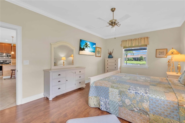 bedroom with a ceiling fan, crown molding, baseboards, and wood finished floors