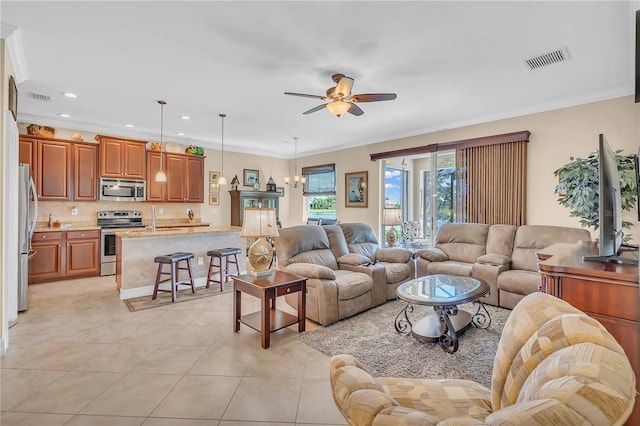 living room with light tile patterned floors, visible vents, a ceiling fan, and ornamental molding