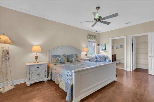 bedroom with baseboards, visible vents, dark wood-style flooring, ornamental molding, and connected bathroom