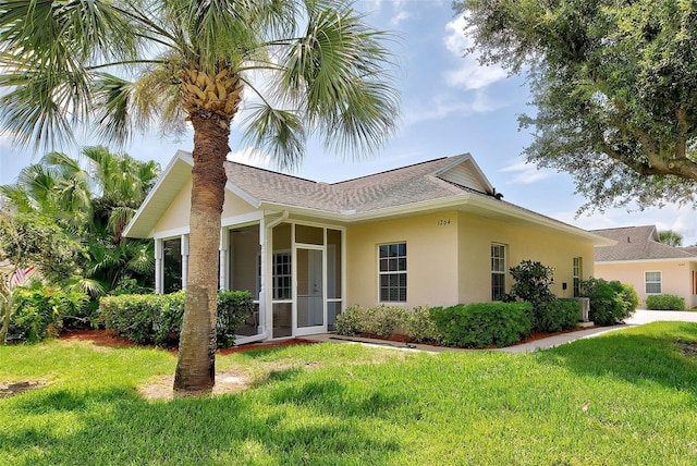 single story home with a sunroom and a front yard