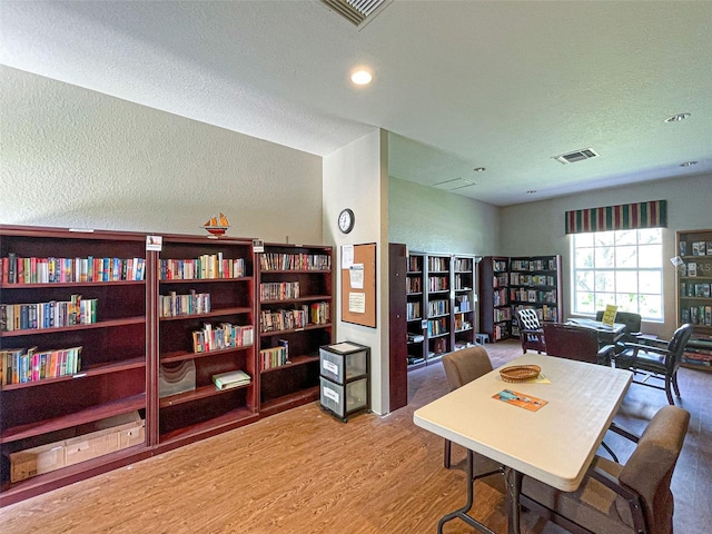 dining area with hardwood / wood-style flooring and a textured ceiling