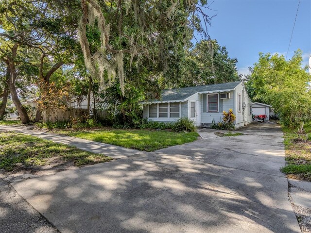 view of front of house with a garage and an outbuilding