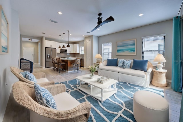 living room featuring ceiling fan and light wood-type flooring