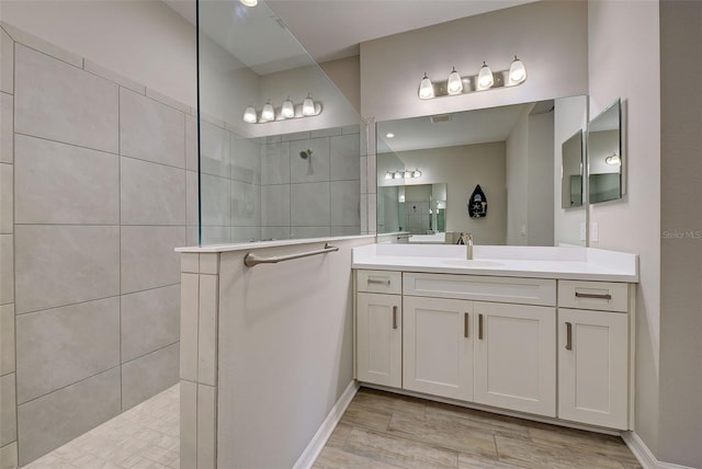 bathroom with vanity and a tile shower